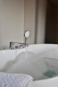 a bathroom sink with a mirror and water at Bed & Bresjes in Breskens