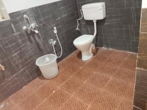 a bathroom with a toilet and a trash can at AB Merridien in Coimbatore