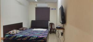 a bedroom with a bed and a flat screen tv at AB Merridien in Coimbatore +7 photos