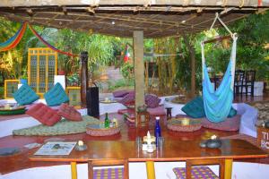 a living room filled with tables and chairs at Namaste Yoga Farm in Gokarna