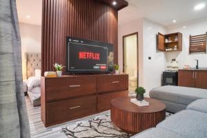 a living room with a tv on a dresser at Bustani Home Studio in Arusha +3 photos