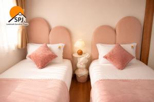 two beds sitting next to each other in a room at Landmark Sunshine Hotel in Osaka