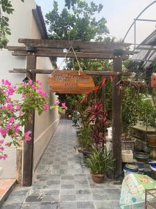 a wooden pergola with a sign for a flower shop at Muối Vừng Home in Ða Gia