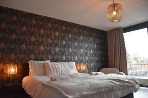 a bedroom with a large bed with a wall at Bed & Bresjes in Breskens