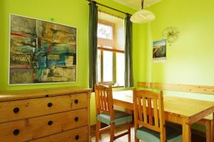 a dining room with a table and chairs and a painting at Penzion Arosa in Růžová