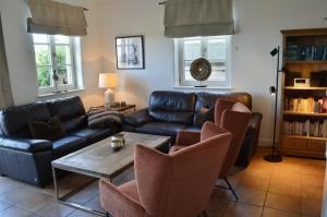 a living room with a couch and a table and chairs at Insel Landhaus Seaside in Gager