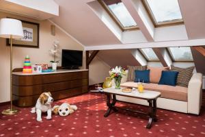 a living room with a dog sitting on the floor at Booking Hotel & Spa in Krakow +37 photos