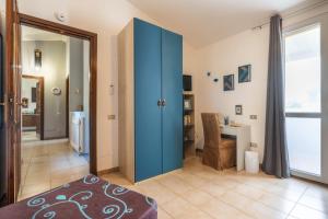 a bedroom with a blue door and a desk at Luxi noa in Quartu SantʼElena +38 photos