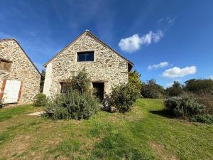 an old stone house on a grass field at 9 La Roche La Bergerie in Saint-Plantaire