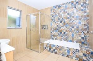 a bathroom with a shower and a tub and a sink at Emu Bay Bliss 'sweeping ocean views' in Emu Bay +22 photos