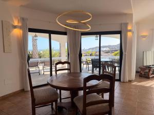 a dining room with a table and chairs and a chandelier at Casa Ronda in Charco del Palo