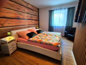 a bedroom with a bed with a wooden wall at Ferienwohnung 1890 in Dettelbach