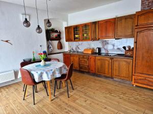 a kitchen with wooden cabinets and a table with chairs at Ferienwohnung 1890 in Dettelbach +7 photos