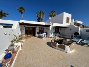 a house with a courtyard with chairs and palm trees at Puerto Chico F in Playa Blanca