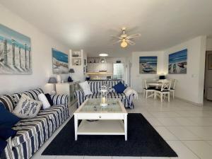 a living room with striped couches and a table at Puerto Chico F in Playa Blanca