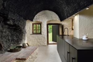 a kitchen with a sink and a stone wall at Alpine Contrapposto in Solčava
