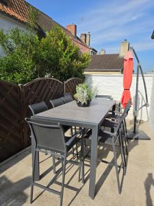 a gray table and chairs on a patio at Ô Charme Cachet in Arques