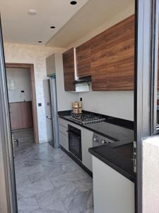 a kitchen with white appliances and wooden cabinets at Blue Horizon Mansouriah in Mohammedia +4 photos