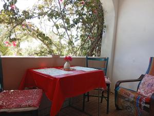 a red table with a vase with a flower on it at Bohème Valdareina, PISCINE CHAUFFEE, Bénagil-Carvoeiro in Carvoeiro
