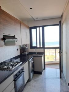 a kitchen with a stove top oven next to a window at Blue Horizon Mansouriah in Mohammedia