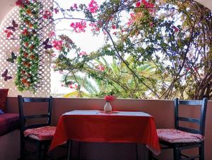 a table and two chairs with a red table and a window at Bohème Valdareina, PISCINE CHAUFFEE, Bénagil-Carvoeiro in Carvoeiro