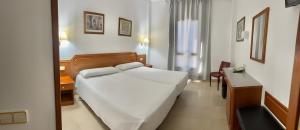 ein Schlafzimmer mit einem großen weißen Bett und einem Schreibtisch in der Unterkunft Hotel Humanes in Humanes de Madrid + 35 Fotos