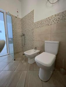a bathroom with a toilet and a sink at Residence Kullat in Velipojë +34 photos