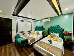 a hotel room with two beds and a chair at Bảo Anh Hotel in Hanoi