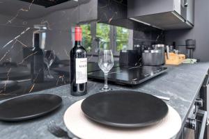 a bottle of wine and a glass on a kitchen counter at Modern Cambridge Studio in Milton