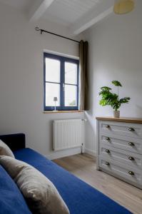 a bedroom with a bed and a dresser with a plant at Am Achterwasser DORF 12 in Rankwitz