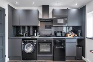 a kitchen with a washing machine and a washer at Modern Cambridge Studio in Milton +16 photos