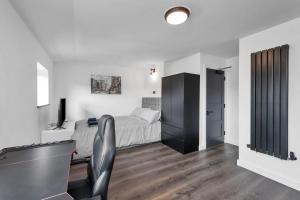 a bedroom with a bed and a desk with a chair at Modern Cambridge Studio in Milton