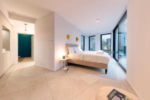 a bedroom with a bed and large windows at Wok Rooms in Brussels