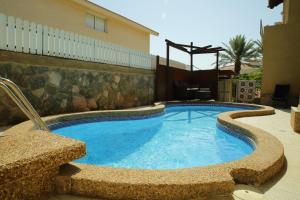 a large swimming pool in a yard with a building at Amazing Villa in Eilat