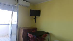 a room with a tv on the wall and a table at Il respiro del mare in Montesilvano