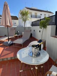 a patio with a table and an umbrella on a roof at Boutique Suites in Arcos de la Frontera