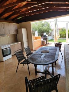 a dining room with a table and chairs and a kitchen at Sunshine in Skala Marion