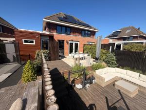 a backyard of a house with a couch and a table at Hart van Petten in Petten