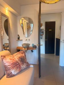 a bathroom with a sink and a couch and a mirror at Hart van Petten in Petten +40 photos