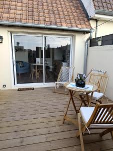 a patio with two chairs and a table on a deck at Bienvenue chez Marceau in Le Crotoy +11 photos