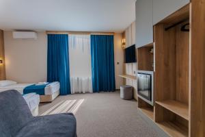 a hotel room with a bed and a television at Family Hotel Deja Vu in Ravda