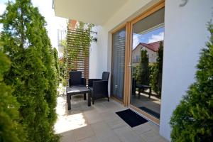 a patio with chairs and a table on a balcony at Chmielowa2 - Apartamenty in Rowy