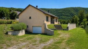 a house with a garage in the middle of a yard at Gite d'arnaud & emilie in Laifour