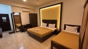 a hotel room with two beds and a mirror at Jerry's Chateau in Pondicherry