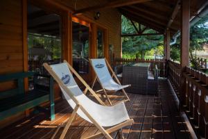 two chairs sitting on the porch of a house at Szőcs-birtok - The old house in Izvoare +19 photos