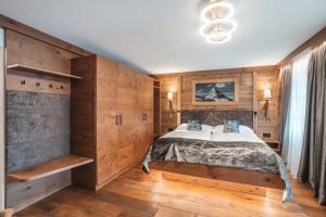 a bedroom with wooden walls and a large bed at La Perle Apartments in Zermatt