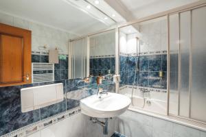 a bathroom with a sink and a shower at La Perle Apartments in Zermatt +9 photos