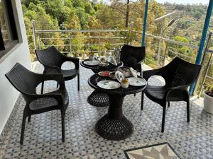 a group of chairs and tables on a balcony at The Plum in Mukteshwar