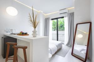 a white bedroom with a mirror and a bed at Pyramid Ateliero Hotel Canggu in Canggu