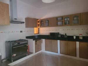 a kitchen with wooden cabinets and a stove top oven at Good Times in Kampala